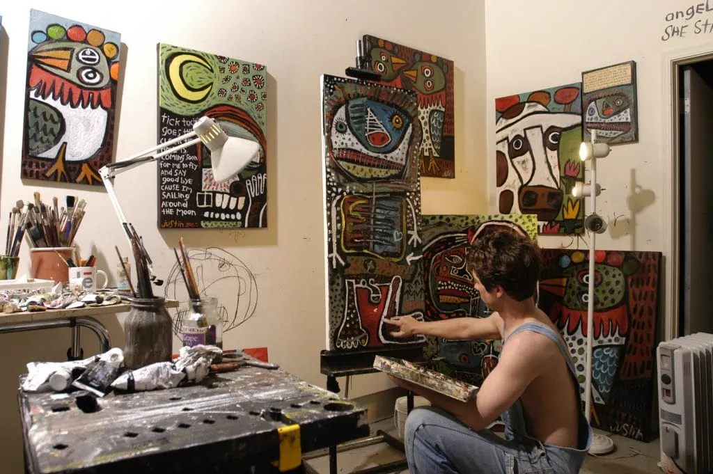 Intimate theatre space with arched landscape murals and blue seating